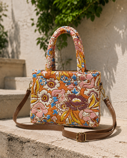 Amber orange floral jacquard mini tote bag with padded top handle and detachable tan leather crossbody strap with gold hardware